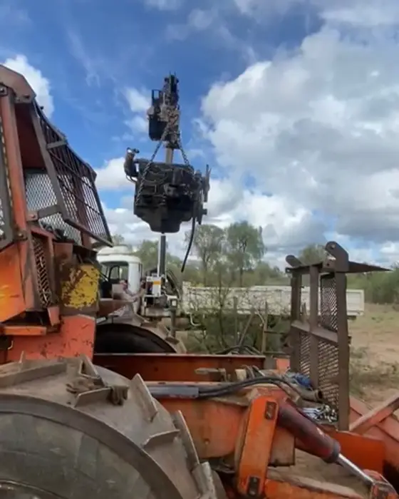 Grúa levantando el motor de un tractor